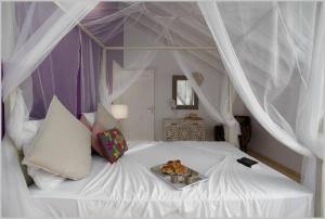 圣吕斯Villa Mango 150 mètres plage à pied的一张白色的床,上面有两只泰迪熊