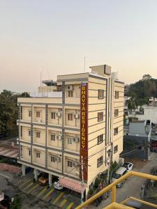 巴德拉恰拉姆SRI BHAVYARESIDENCY的一座白色的大建筑,上面有黄色的标志