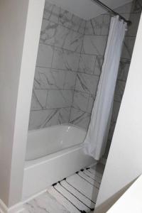 托莱多NEW Bright & Modern 3BR// Conveniently Located//Toledo Stones Throw的带浴缸和淋浴帘的浴室