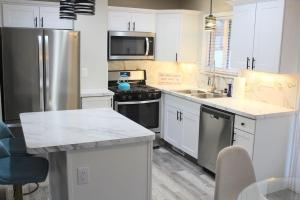 托莱多NEW Bright & Modern 3BR// Conveniently Located//Toledo Stones Throw的厨房配有白色橱柜和炉灶烤箱。