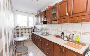 什切齐内克Słoneczny Apartament的厨房配有木制橱柜、水槽和桌子
