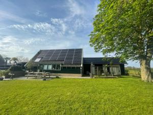 WijdenesVakantiehuis Het Uilennest的屋顶上设有太阳能电池板的房子