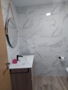 波多诺伏Apartamento en casa Portonovo vacaciones的白色的浴室设有水槽和镜子