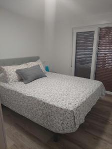 波多诺伏Apartamento en casa Portonovo vacaciones的一间卧室配有一张带枕头的床