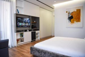地拉那The Wilson Tirana的一间卧室配有一张床和一台平面电视