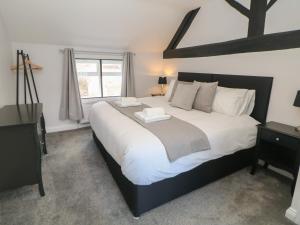 阿什伯恩Kennedy's Cottage的卧室配有一张大白色床和窗户