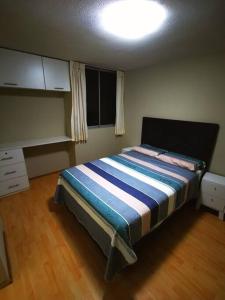 塔克纳Hermoso departamento en condominio的一间卧室配有一张带蓝白色毯子的床