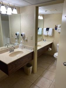 布兰森The Boardwalk Inn的一间带两个盥洗盆和大镜子的浴室