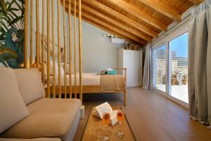 贝尼蔡斯Sea & Cliff Luxury Suites的客房设有床、沙发和窗户。