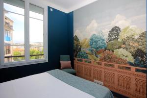 戛纳Appartement 5 min des plages Croisette的卧室设有大窗户,墙上挂有绘画作品