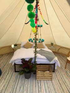 Venn OtteryBowhayes Farm - Camping and Glamping的帐篷内的一张床位,配有绿色气球