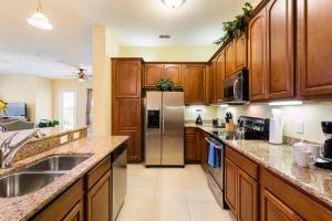 奥兰多Florida Palms的厨房配有木制橱柜和不锈钢冰箱。