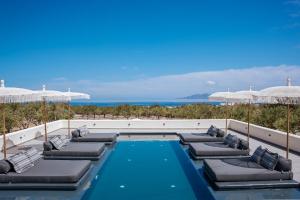 卡特瑞杜斯Zaitun Luxury Suites的一个带躺椅和遮阳伞的游泳池