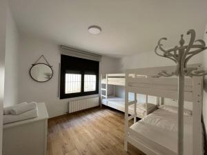 赫罗纳Can Mosqueroles casa en Castellfollit de la Roca的一间卧室设有两张双层床和一扇窗户。