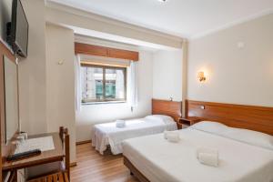 法蒂玛Santa Barbara by Umbral的酒店客房设有两张床和窗户。