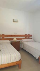 圣费兰-德瑟斯罗CASA PATY, Estudio rural. Sant Ferran FORMENTERA的两张睡床彼此相邻,位于一个房间里