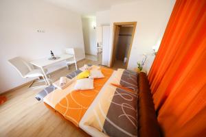 比比涅Rooms & Studio apartmani Flower的一间卧室配有一张带橙色毯子的床