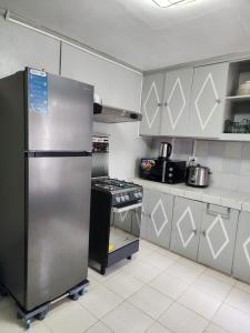 哥打巴托LUXURY HOME的厨房配有不锈钢冰箱和炉灶。