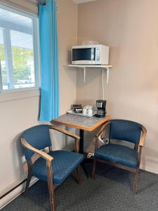 克雷斯顿斯基摩霍恩酒店的一间配备有桌子和两把椅子及微波炉的客房