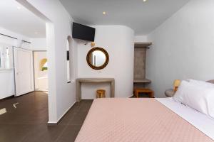 卡特瑞杜斯Zaitun Luxury Suites的卧室配有一张床,墙上设有镜子