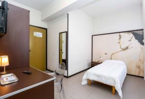 西维尔诺瓦·马尔凯日光浴酒店 的一间卧室配有一张床、一张书桌和一台电视