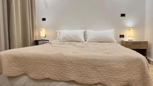 拉巴特Cozy Appartement in a Villa close to Mahaj Riad Rabat的一间卧室配有一张带两盏灯的大型白色床。