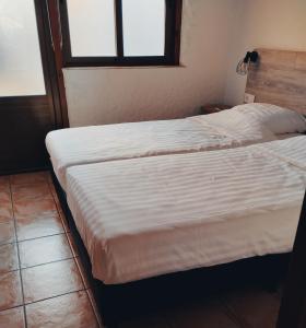 La MuradaThe Olive Mill的一间卧室设有两张床和窗户。