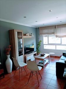 卡尔达斯·德·雷斯Marvera的客厅配有椅子、桌子和电视