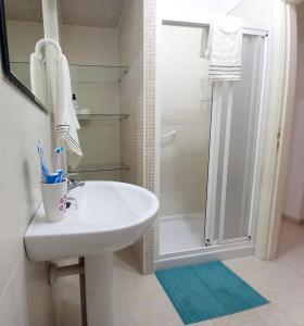 圭马尔港Disfruta en 1ª línea de playa的浴室配有白色水槽和淋浴。