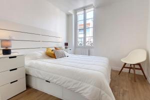 戛纳HENRI CAMILLE REAL ESTATE - Bambou- One bedroom center的白色卧室配有白色的床和椅子