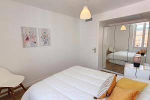 戛纳HENRI CAMILLE REAL ESTATE - Bambou- One bedroom center的白色卧室配有床和镜子