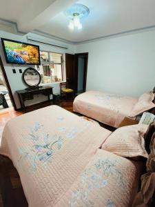 奥塔瓦洛Chaska Hotel的一间卧室配有两张床和一台平面电视