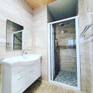 宜兰市妃民宿的浴室配有白色水槽和淋浴。
