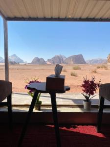 瓦迪拉姆Sunrise Colors Camp Wadi rum的沙漠景客房中的一张桌子