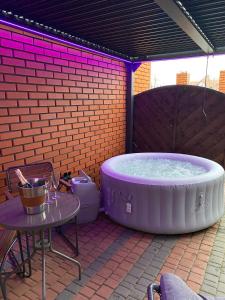 格涅兹诺Apartament "Love Island" z Jacuzzi SPA dla Dwojga的庭院内的大型热水浴池配有桌子