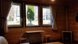 富良野森林之友山林小屋的客房设有3扇窗户、1张桌子和凳子