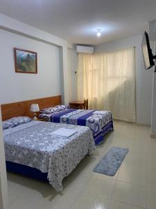 伊基托斯Alojamiento Everglow的一间卧室设有两张床和窗户。