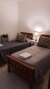 GualeguaychúLA ESTACION的酒店客房设有两张床和一张桌子。