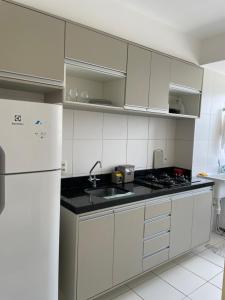 圣路易斯APARTAMENTO ACONCHEGANTE PROXIMO A PRAIA DO ARACAGY的厨房配有白色橱柜和白色冰箱。