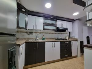 卡利Hospedaje Casa Leví的厨房配有黑白橱柜和水槽