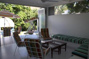 梅尔加Finca Summerland ecohotel的庭院配有桌椅和遮阳伞。