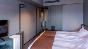 东京La Vista Tokyo Bay的一间卧室配有一张床和一台电视。