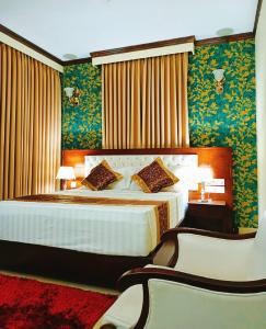 巴纳内拉斯Hotel Crystal Rose - Sylhet的一间卧室配有一张带绿色壁纸的大床