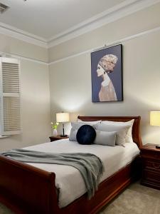 阿德莱德Villa on Melbourne St的卧室配有一张大床,墙上挂着一幅画
