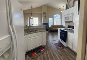 拉斯维加斯Gorgeous home away from home的厨房配有白色橱柜、水槽和冰箱。