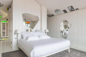 派拉索梅客尼适酒店的白色的卧室配有白色的床和镜子