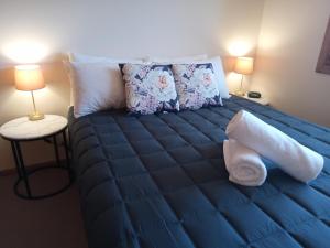 福斯特福斯特棕榈树汽车旅馆的一张位于带蓝色床单和枕头的客房的床位