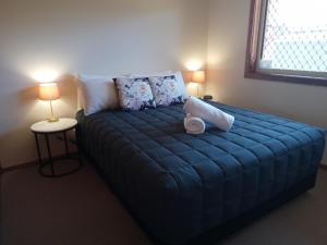 福斯特福斯特棕榈树汽车旅馆的一张蓝色的床,房间有两个灯
