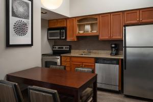 林伍德Residence Inn Seattle North/Lynnwood Everett的厨房配有桌子和不锈钢冰箱。