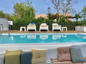 法鲁Casa Lavadeira - VINHAS de NEXE的游泳池旁的沙发和椅子